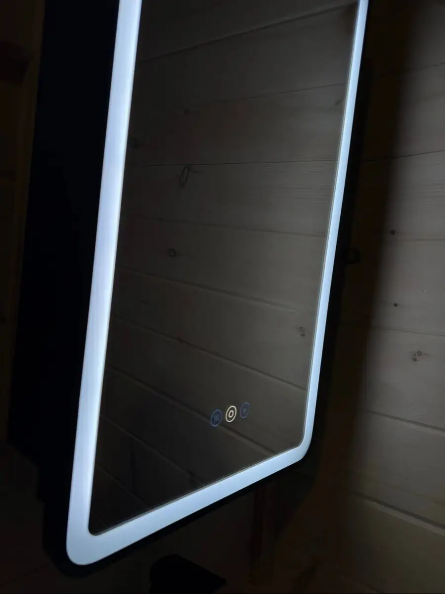 Lit LED bathroom mirror in a cabin with pine walls